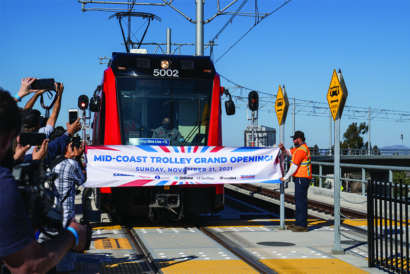 Attendees cheer during a ceremonial banner breaking at the UC San Diego Central Campus Trolley Station